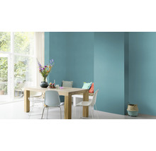 Lichte eetkamer met houten tafel, stoelen en muur in turquoise
