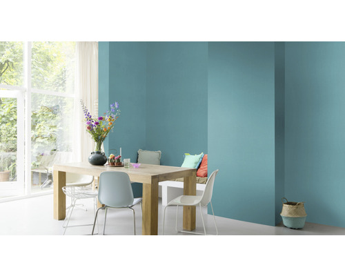 Lichte eetkamer met houten tafel, stoelen en muur in turquoise