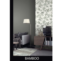 Woonkamer met bamboebladmotief behang, bank, lamp en dressoir