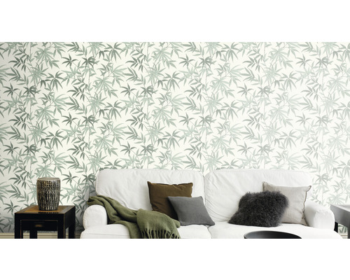 Woonkamer met bank en behang met bladerpatroon