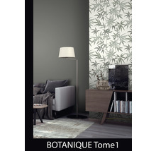 Woonkamer met bank, vloerlamp en een muur met behang met bladerpatroon.