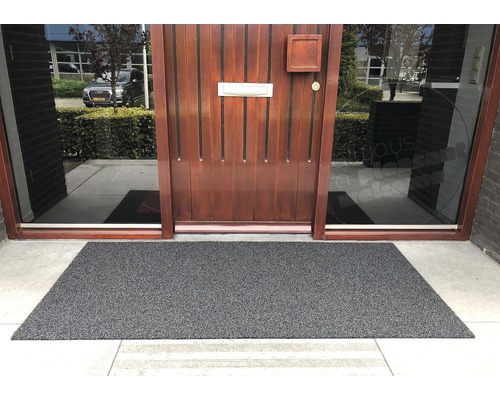 Grijze deurmat voor een voordeur