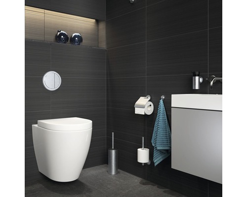 Moderne badkamer met hangtoilet, wastafel en donkere tegels