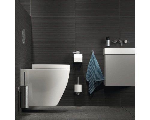 Moderne badkamer met hangtoilet, wastafel en donkere tegels