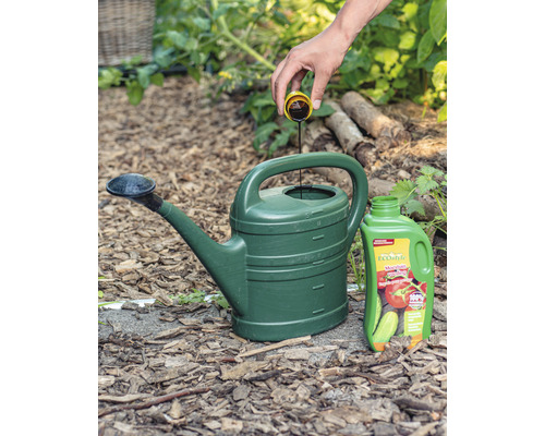 Gieter wordt gevuld met vloeibare meststof, daarnaast een fles vloeibare meststof