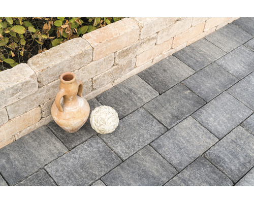 Tuinpad geplaveid met straatstenen, versierd met een amfora en een bol