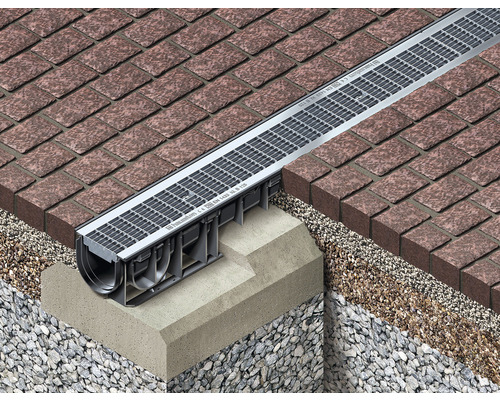 Detailopname van een metalen afwateringsgoot in straatstenen