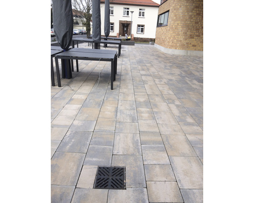 Buitengebied met straatstenen, tafels en afdekking
