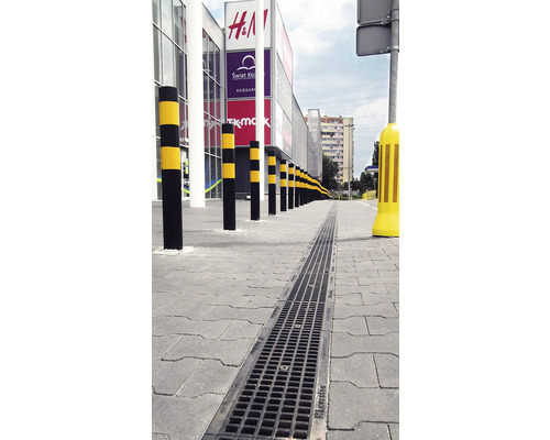 Buitenfoto met afwateringsgoot en afzetpalen voor een winkelcentrum.