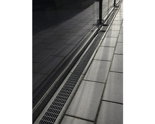 Vloerafvoer met rooster naast straatstenen