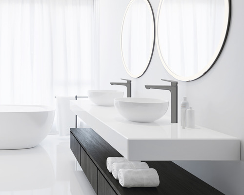 Lichte badkamer met dubbele wastafel, opzetwastafels, kranen, ronde spiegels en een bad