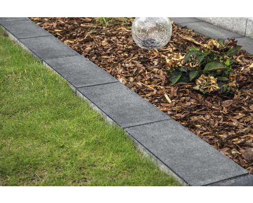 Tuin met gazon, boomschors en stenen border