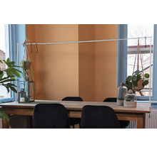 Eettafel met decoraties, waaronder hangplanten, windlichten en planten onder glazen stolpen.