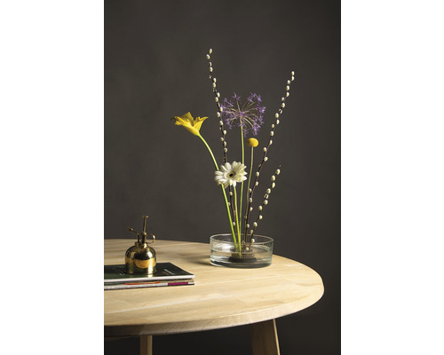 Bloemstuk in een glazen vaas op een houten tafel