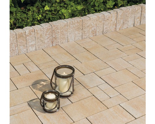 Bestrate patio met kaarslantaarns en een begrenzingsmuur