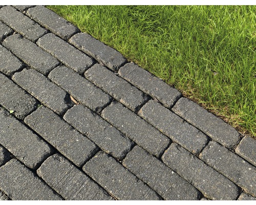 Grijze straatstenen naast groen gras