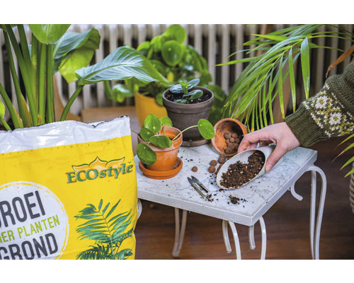 Scene met potgrond, planten en een persoon die aarde in een pot schept