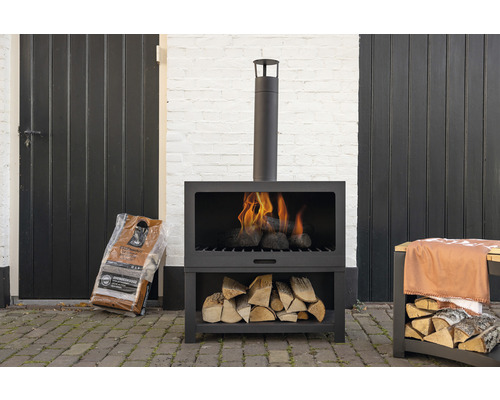 Buitenkachel met brandhout en houtblokken op een terras