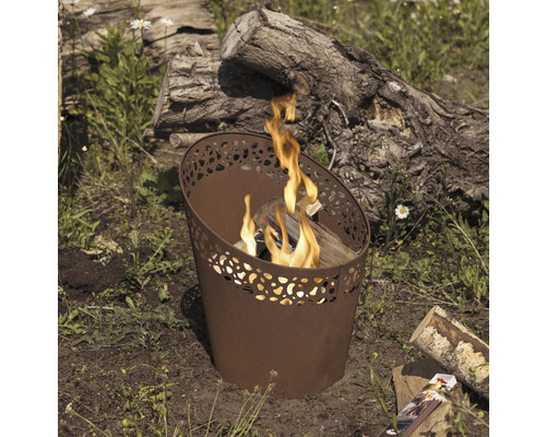 Metalen vuurkorf met hout en vlammen in de tuin