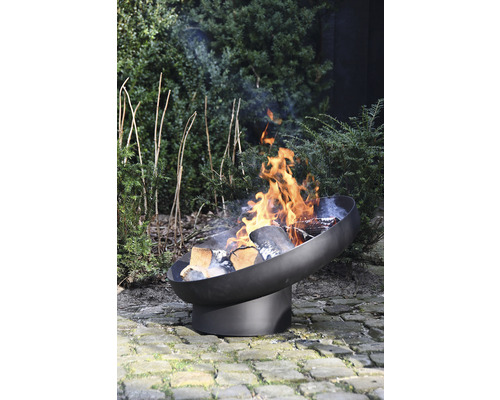 Metalen vuurplaats met brandend hout in de tuin