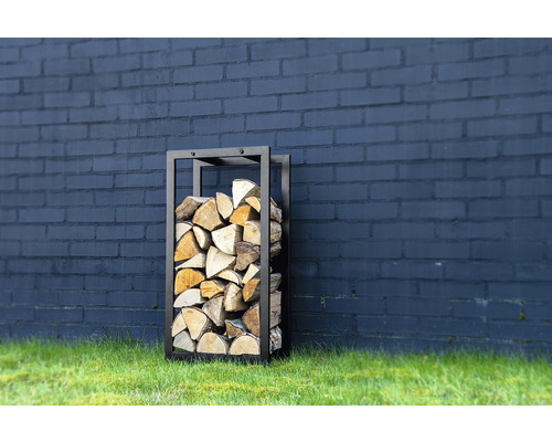 Metalen brandhoutrek met houtblokken voor een muur