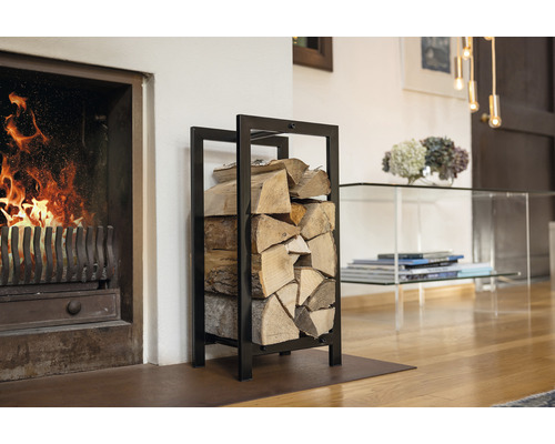 Metalen haardhoutrek naast een open haard met brandend vuur