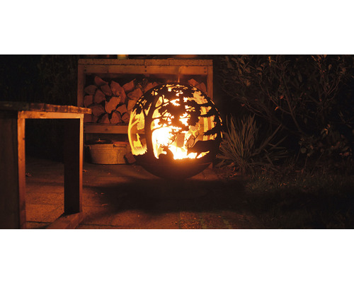 Vuurkorf met hertenmotieven en houtopslag in de tuin