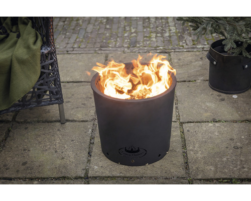 Metalen vuurkorf met brandend hout op een terras