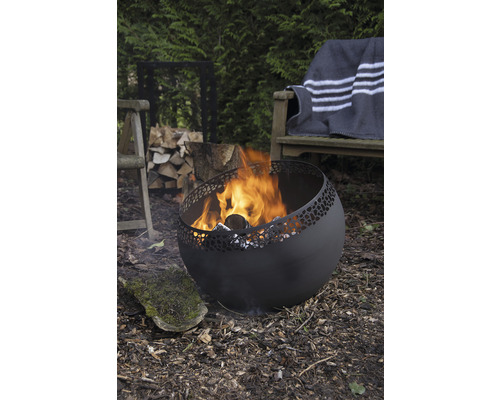 Vuurplaats met vuur in de tuin met brandhout, stoel en bank