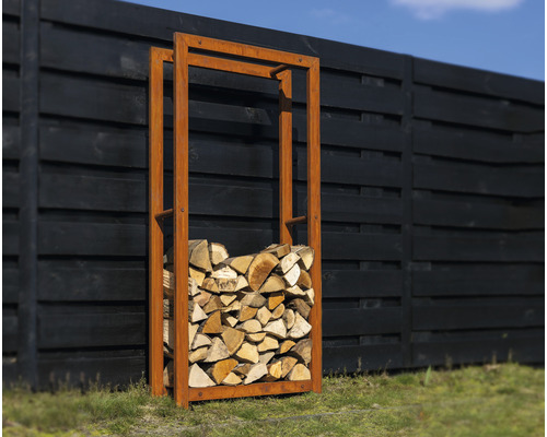 Metalen brandhoutrek met gestapeld hout in de tuin.