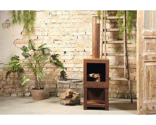 Decoratieve roestkleurige vuurplaats met houtopslag naast houtmand en kamerplant