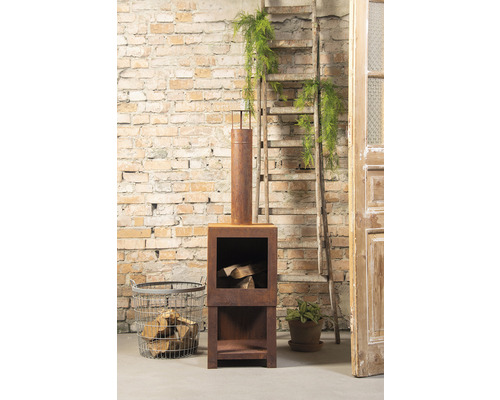 Vierkante stalen open haard met houtopslag, ladder en decoratie tegen een bakstenen muur