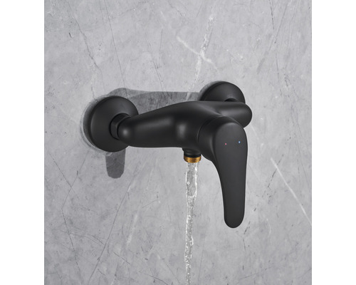 Zwarte douchekraan met stromend water aan een muur