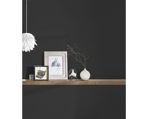 Decoratieve artikelen op een houten plank tegen een donkere muur