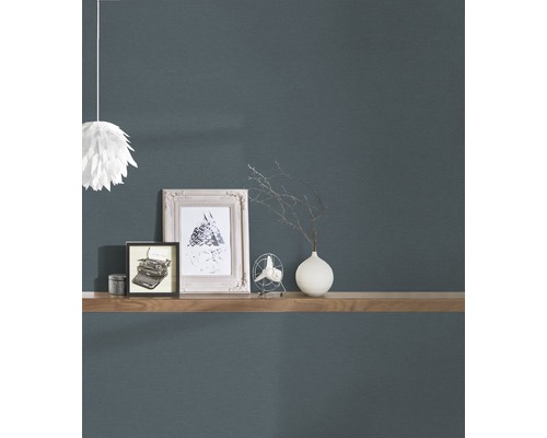 Decoratief behang met een plank waarop fotolijsten, een vaas en een ventilator staan