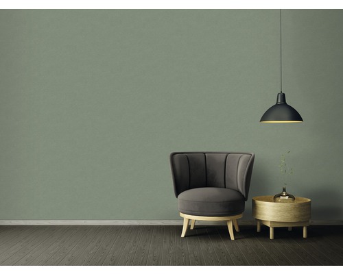 Inrichtingsvoorbeeld met fauteuil, bijzettafel en hanglamp voor een groene wand