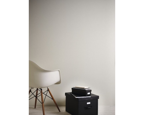 Inrichtingsvoorbeeld met een witte stoel en zwarte opbergdozen tegen een muur