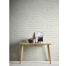 Lichte werkkamer met houten tafel en decoratief bakstenen muurbehang