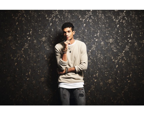 Man met trui voor een muur met patroon