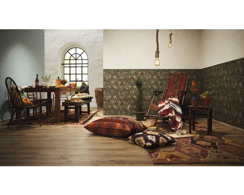 Woonkamer met eettafel, stoelen, bank, ligstoel, vloerkleden en decoratieve kussens in Boheemse stijl.