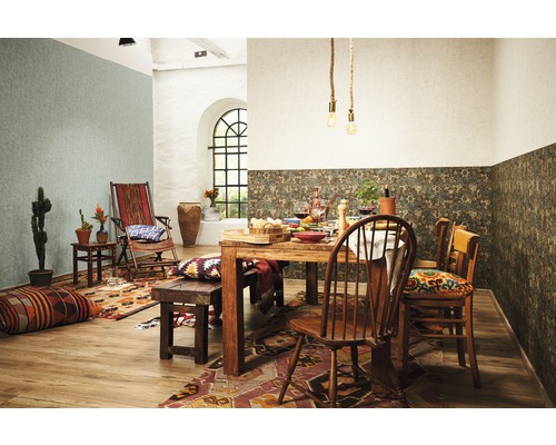 Een eetkamer met houten tafel, stoelen en decoratieve elementen zoals kussens, tapijten en planten