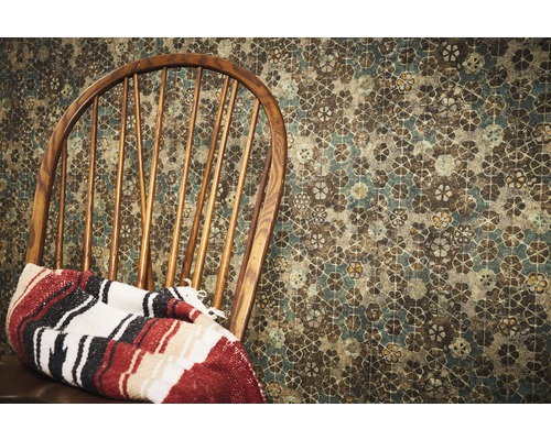 Houten stoel met deken voor een behang met patroon
