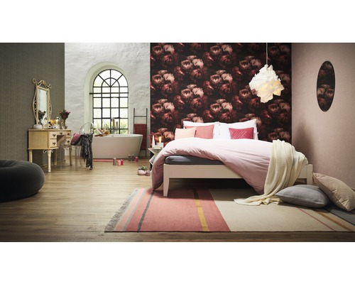 Slaapkamer met bed, vloerkleed, bad en wastafel.