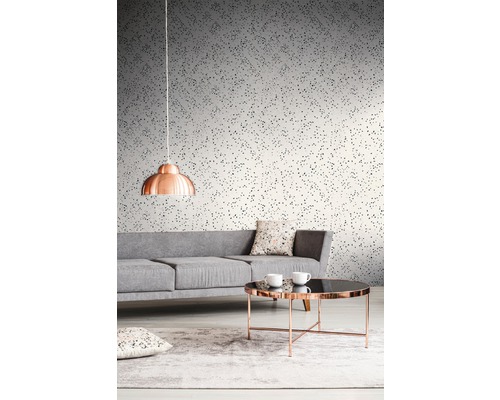 Woonkamer met grijze bank, tafel en behang met print