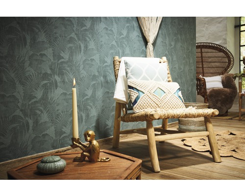 Decoratieve kamer met junglebehang, houten stoel, kussens en kaars.