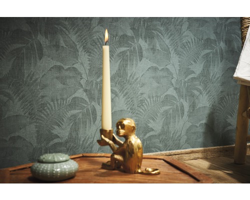 Decoratieve scène met kandelaar in de vorm van een aap, kaars, blik en behang met bladmotief