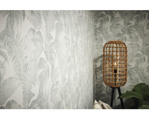 Kamer met tropisch bladerbehang en rotan staande lamp