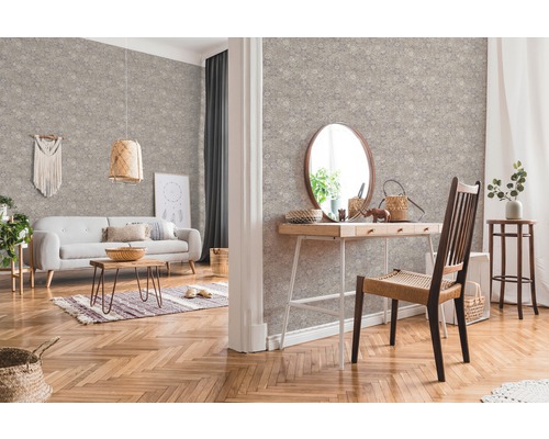 Woonkamer met patroonbehang, bank, tafel en houten vloer