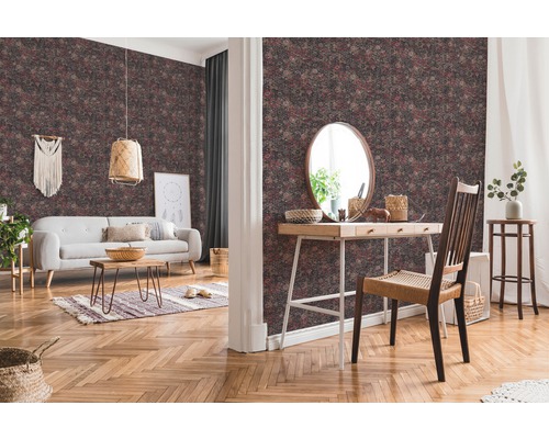 Woonkamer met patroonbehang, bank, tafel en decoraties voor een gezellige sfeer.