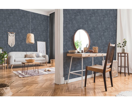 Woonkamer met patroonbehang, bank, tafel en stoel.